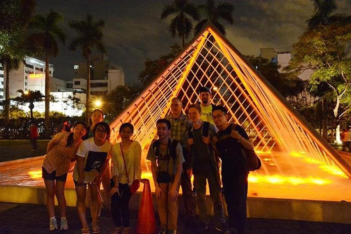 skupina lidí stojící před pyramidou
