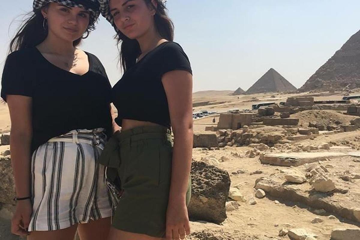 Dvě mladé ženy stojící před pyramidami