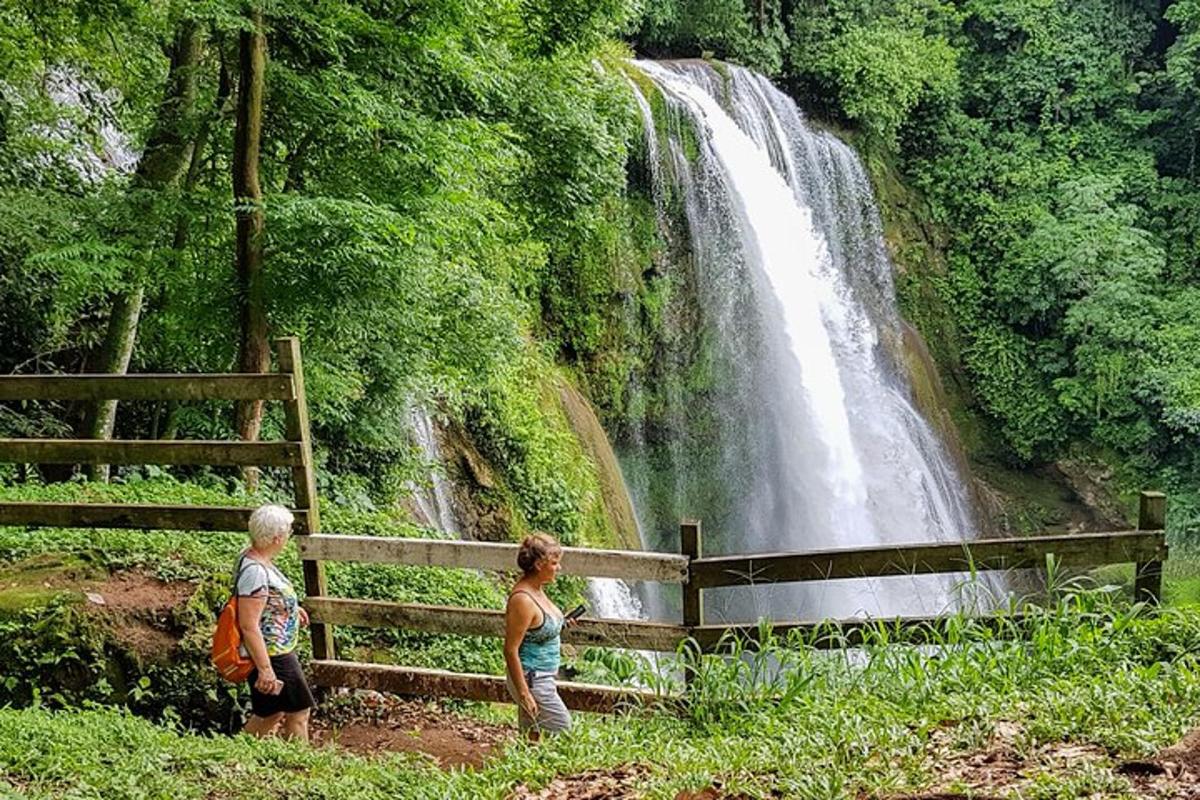 two people standing in front of a waterfall