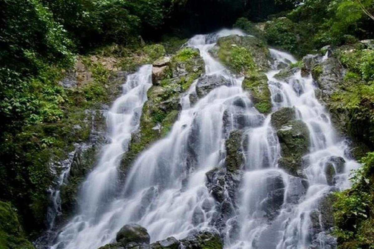una cascata sul fianco di una montagna con rocce