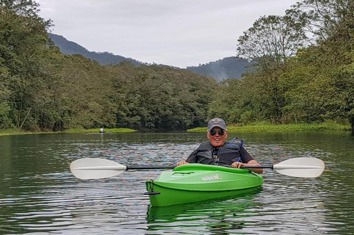 a man in a green kayak on a river