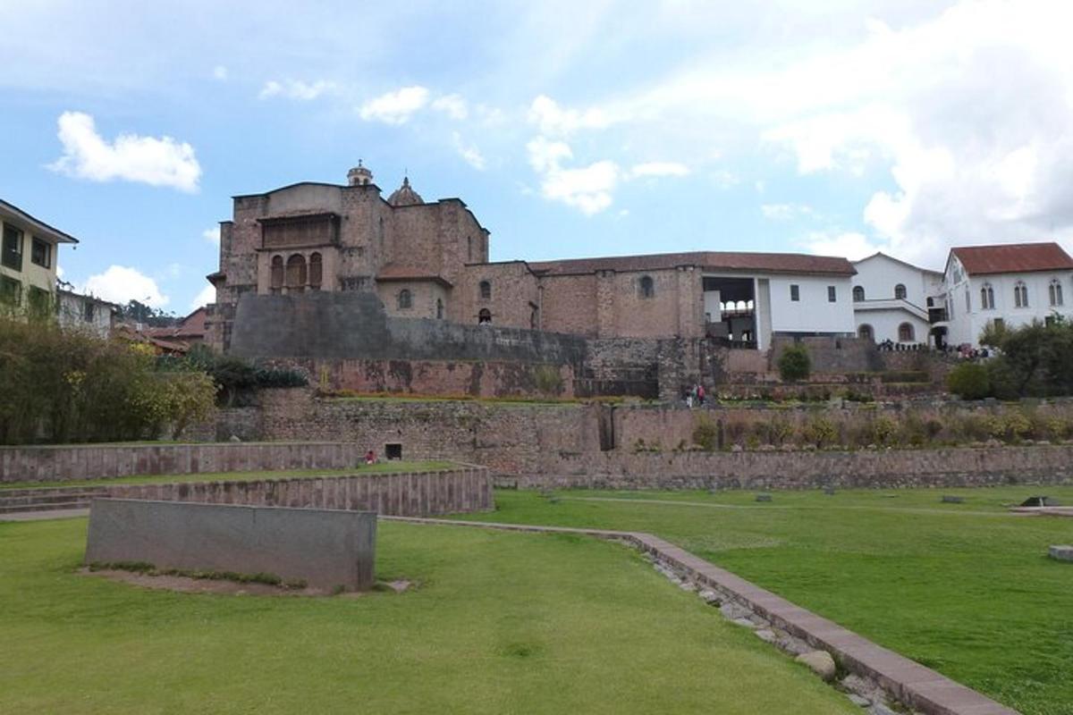 un vecchio castello con un campo verde di fronte