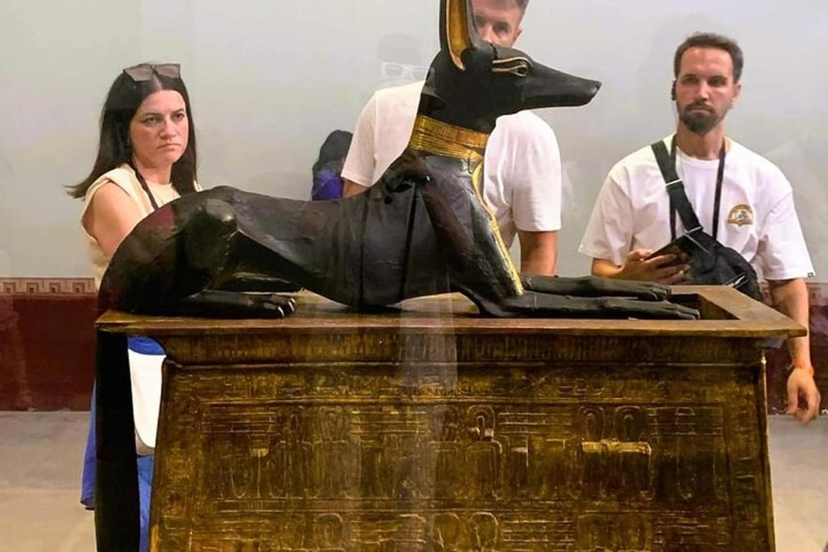 μια ομάδα ανθρώπων που στέκονται γύρω από ένα άγαλμα ενός σκύλου