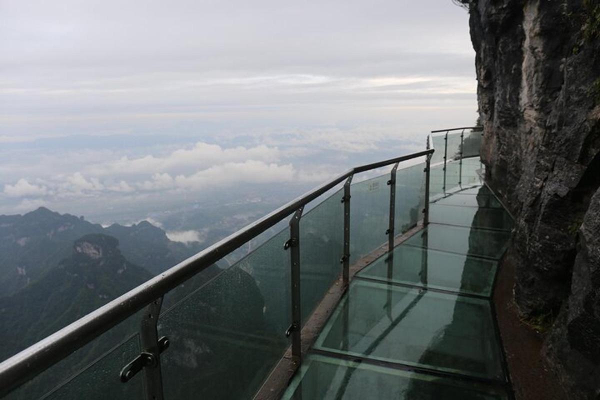 a glass balcony on the side of a mountain