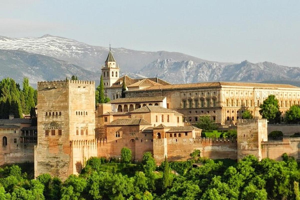 a large building with a clock tower in front of mountains