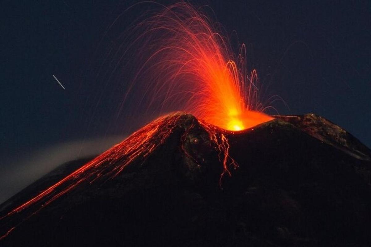 ein ausbrechender Vulkan mit roter Lava auf der Spitze