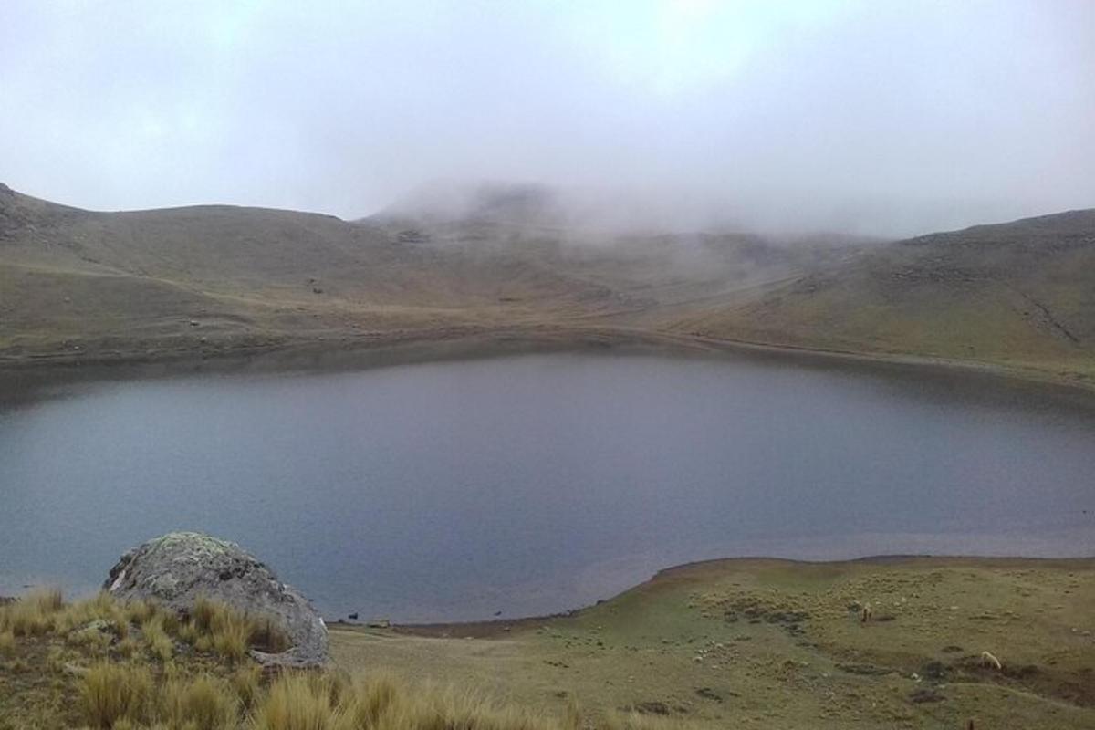 tasik di tengah padang dengan gunung