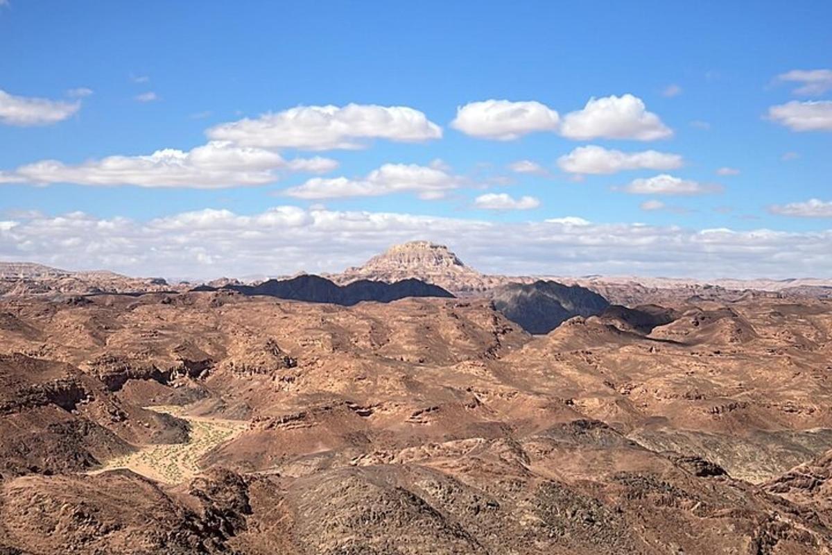uma vista do deserto com uma montanha ao fundo