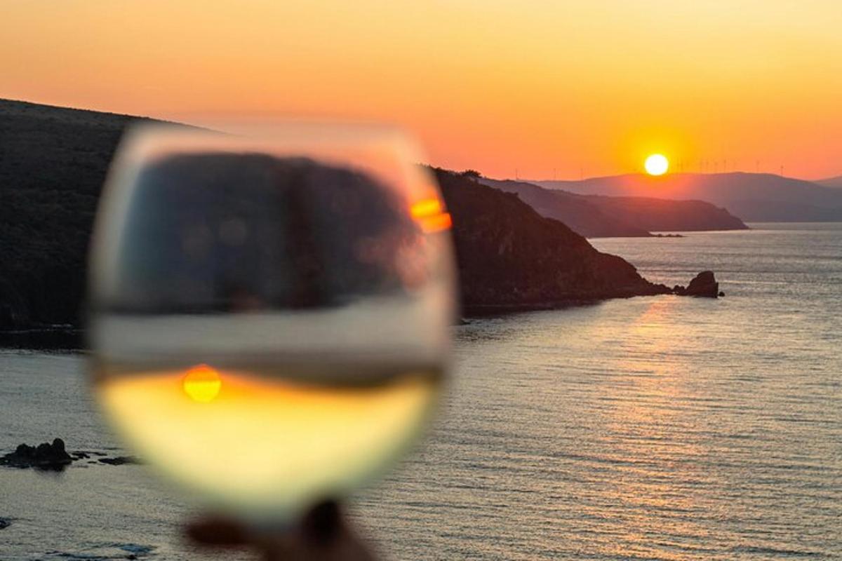 un bicchiere di vino con il tramonto sullo sfondo