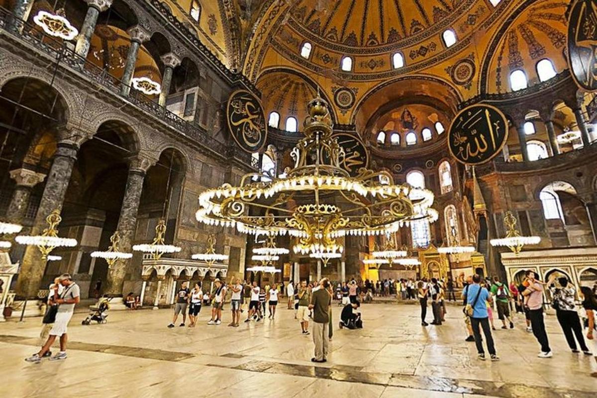 una folla di persone che camminano in un grande edificio con un lampadario