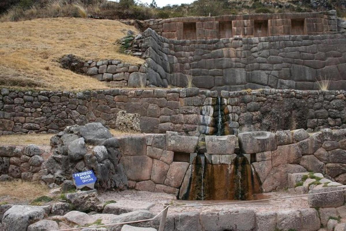 a stone wall with a waterfall in the middle