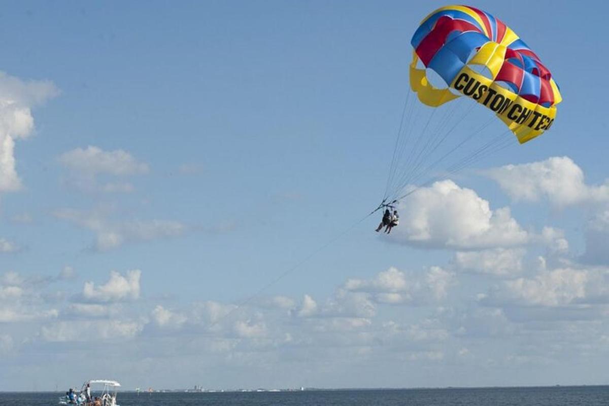 a person flying a kite in the sky over the ocean