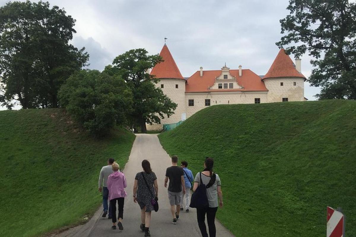 a group of people walking down a road towards a castle