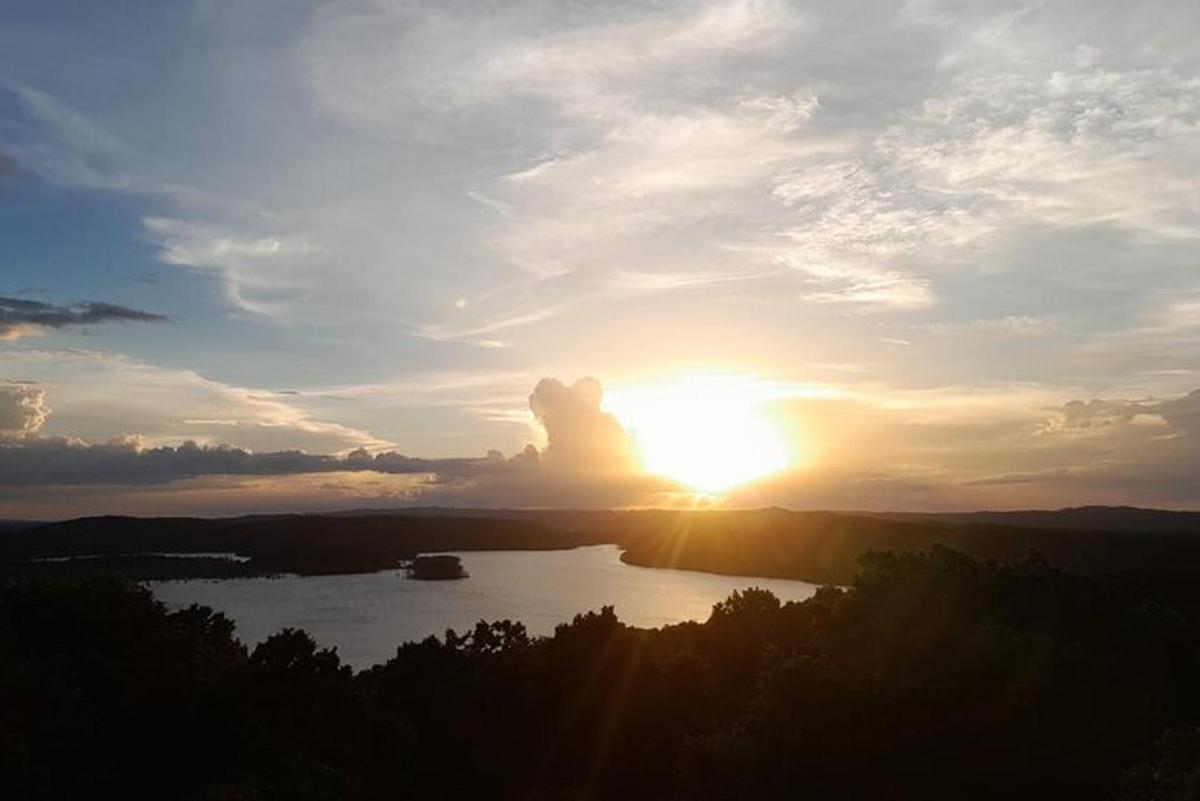 a sunset over a lake with a boat in the water