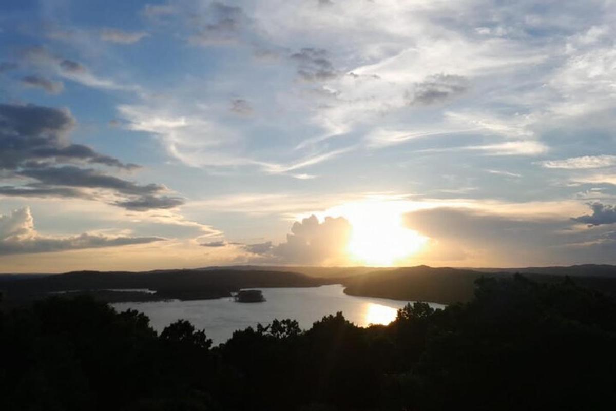 a sunset over a lake with a boat in it