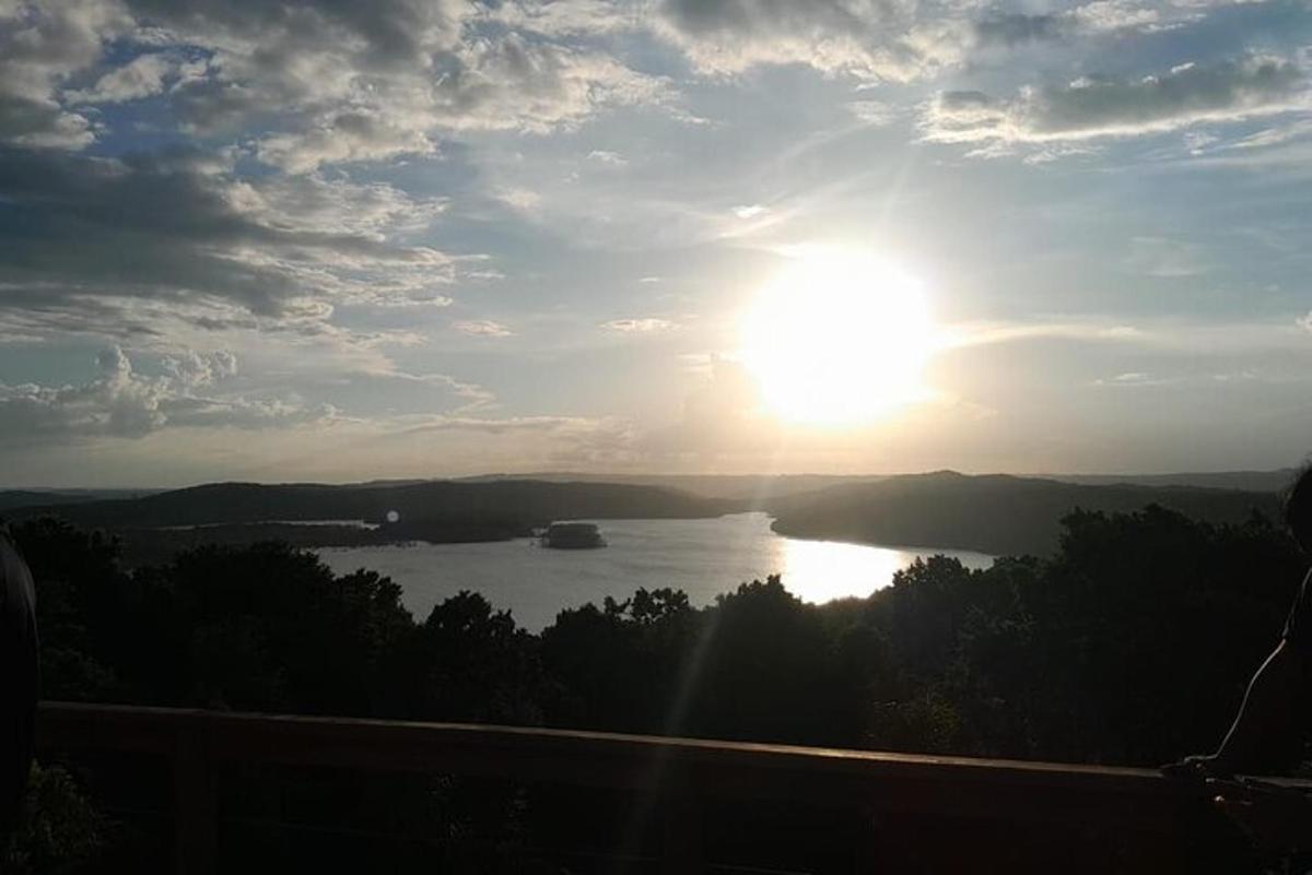 a view of a lake with the sun in the sky