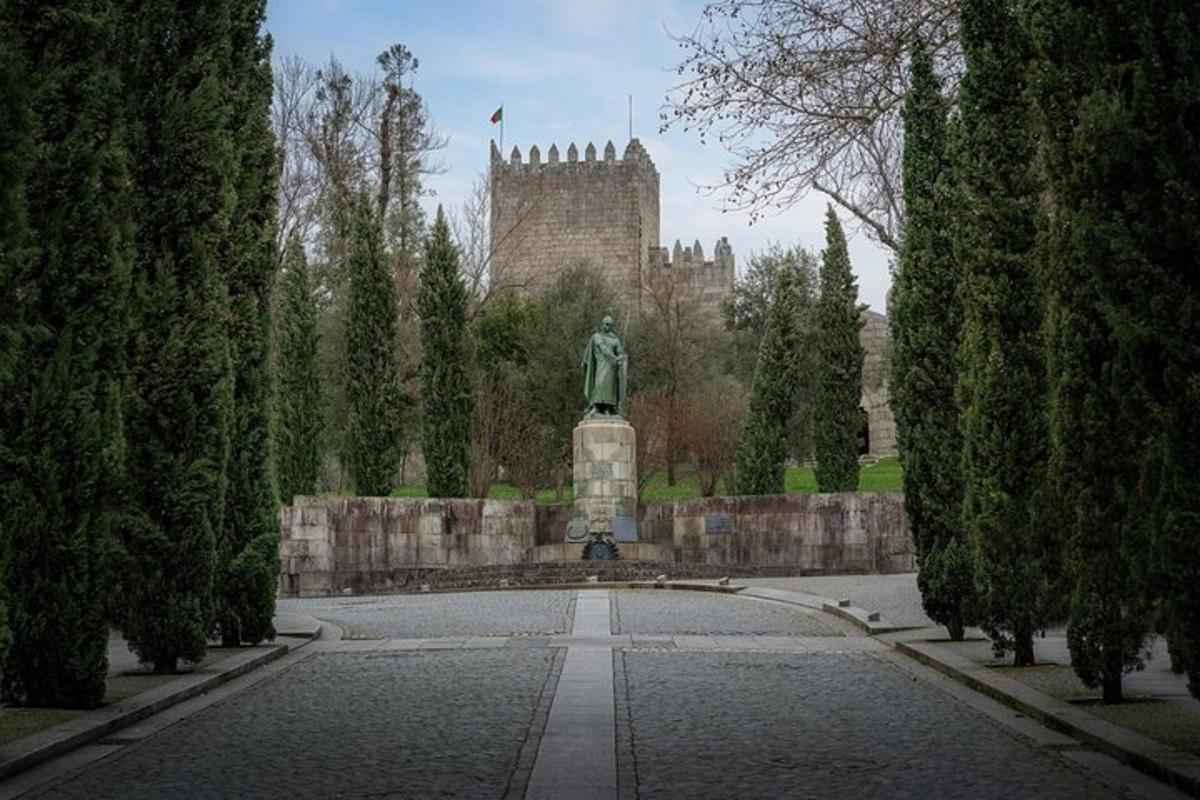 a statue in a park with a castle in the background