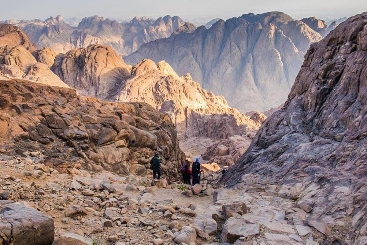 un gruppo di persone che camminano su una montagna rocciosa