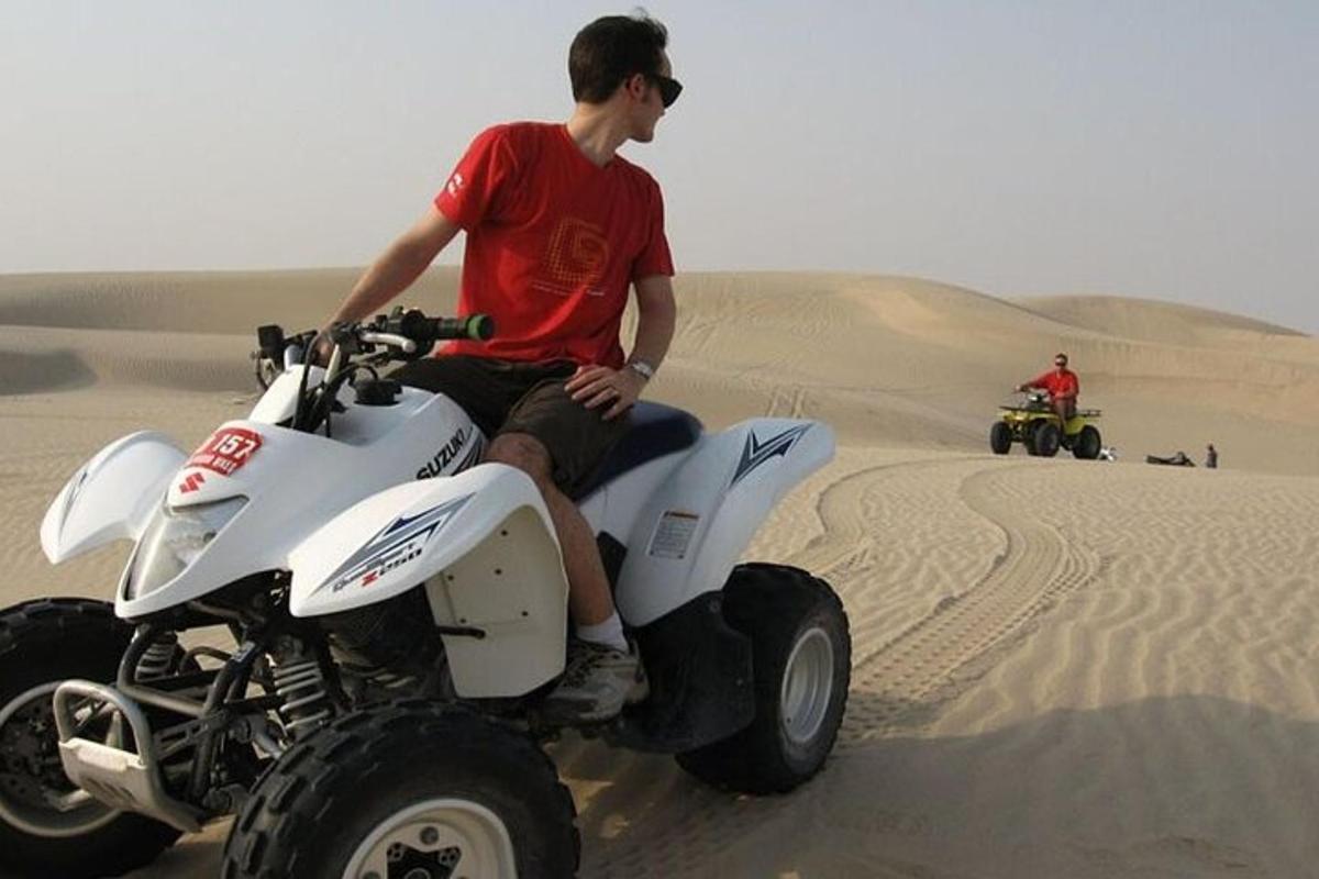 a man sitting on a four wheeler in the desert
