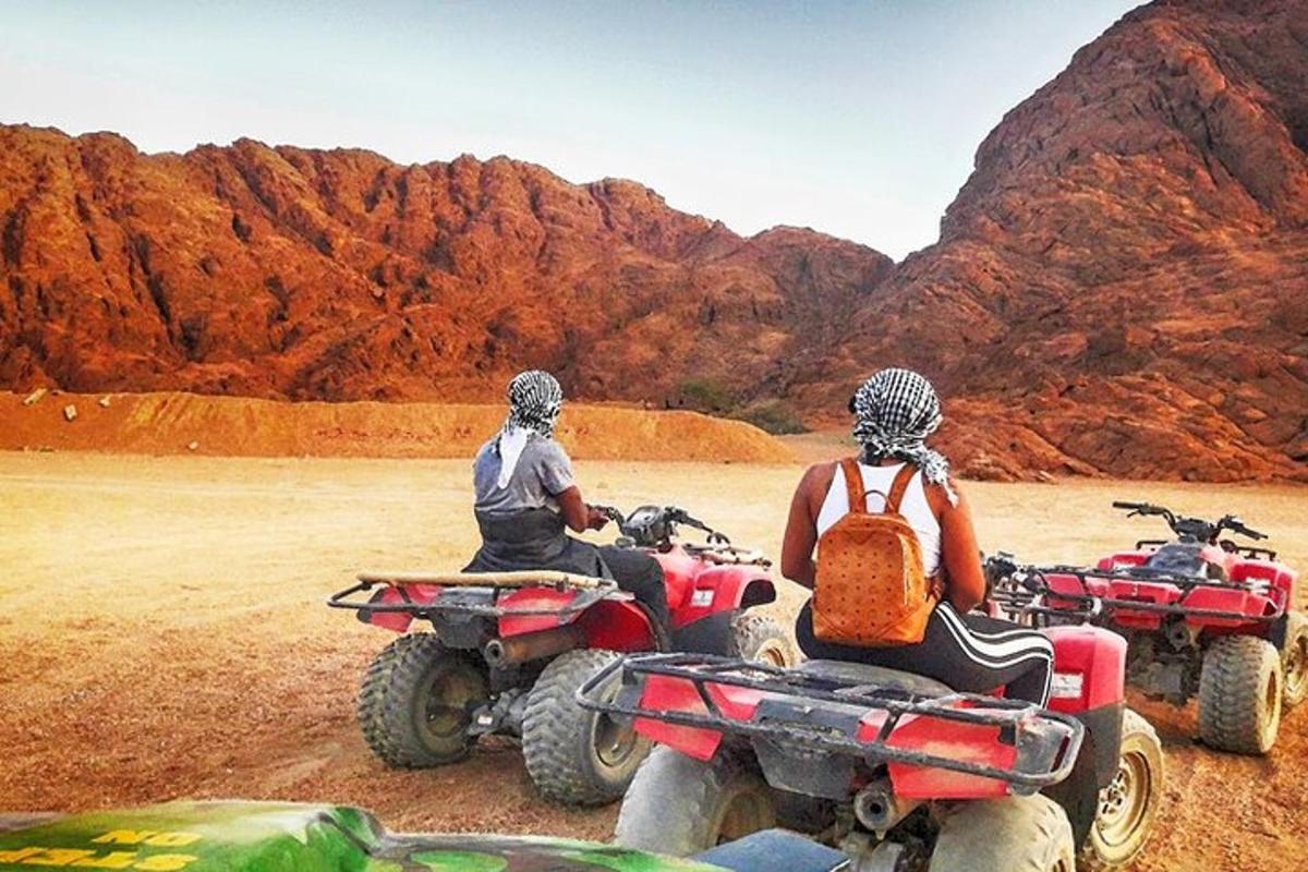 two people are sitting on atvs in the desert