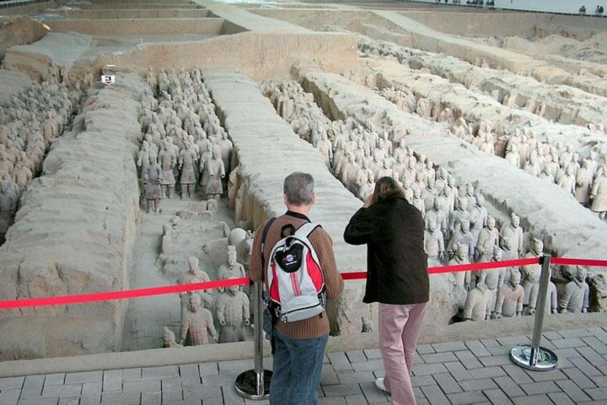 a man and a woman standing in front of a wall of sheep