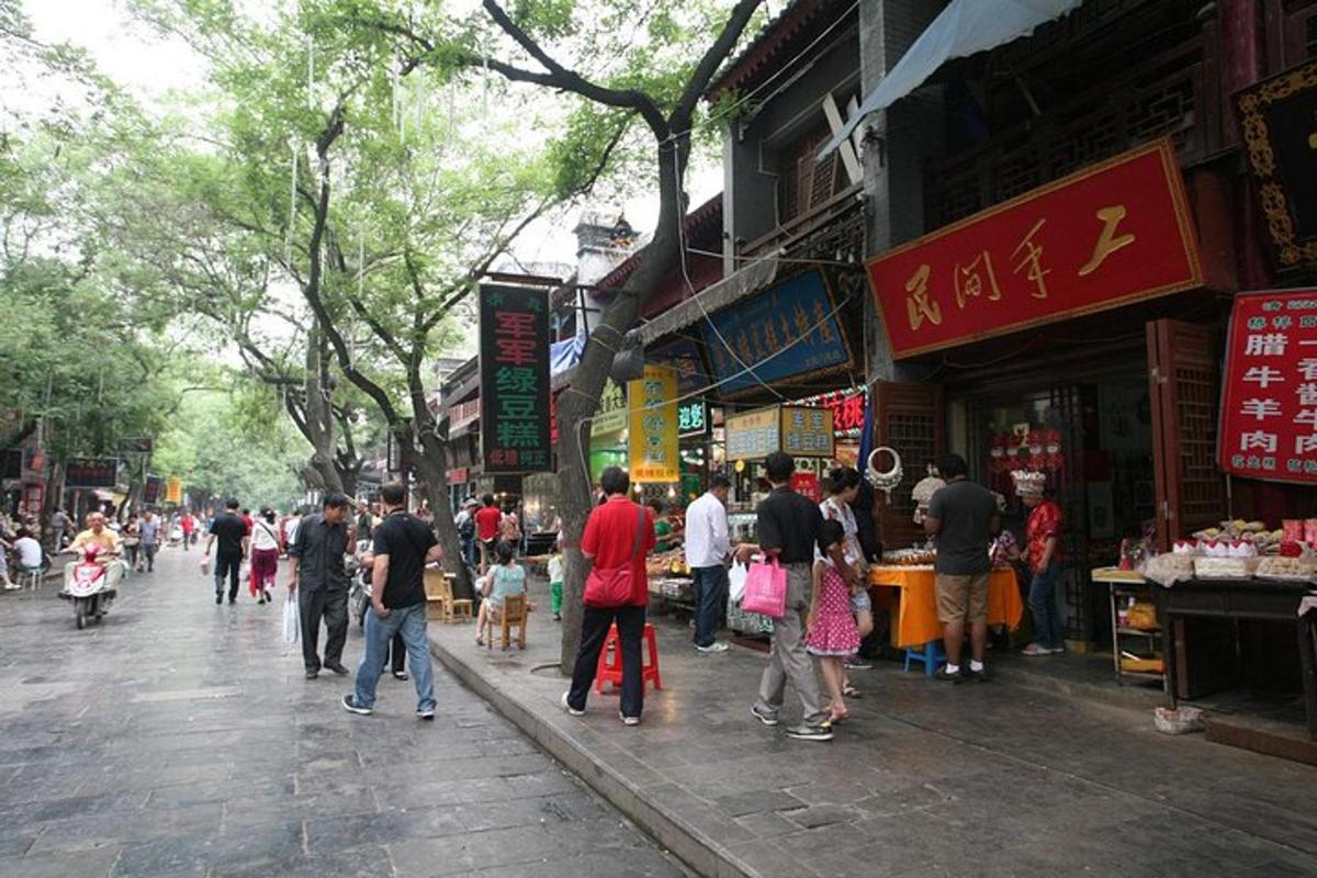 a group of people walking down a street in a market