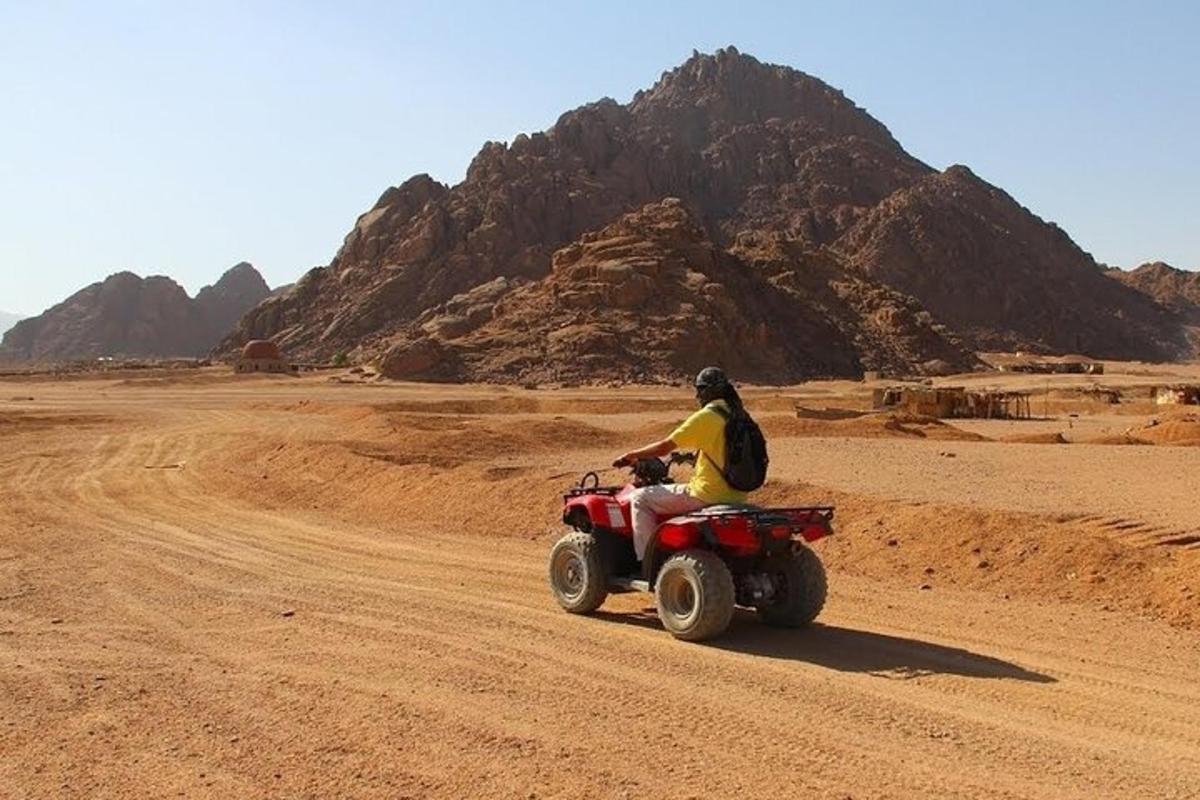 un uomo in sella a un quad nel deserto