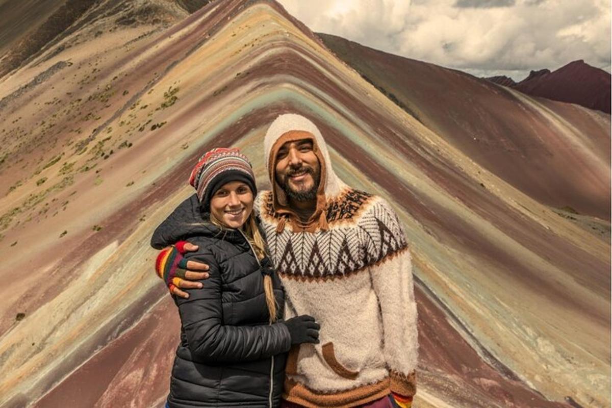 un uomo e una donna in piedi davanti a un dipinto di una montagna