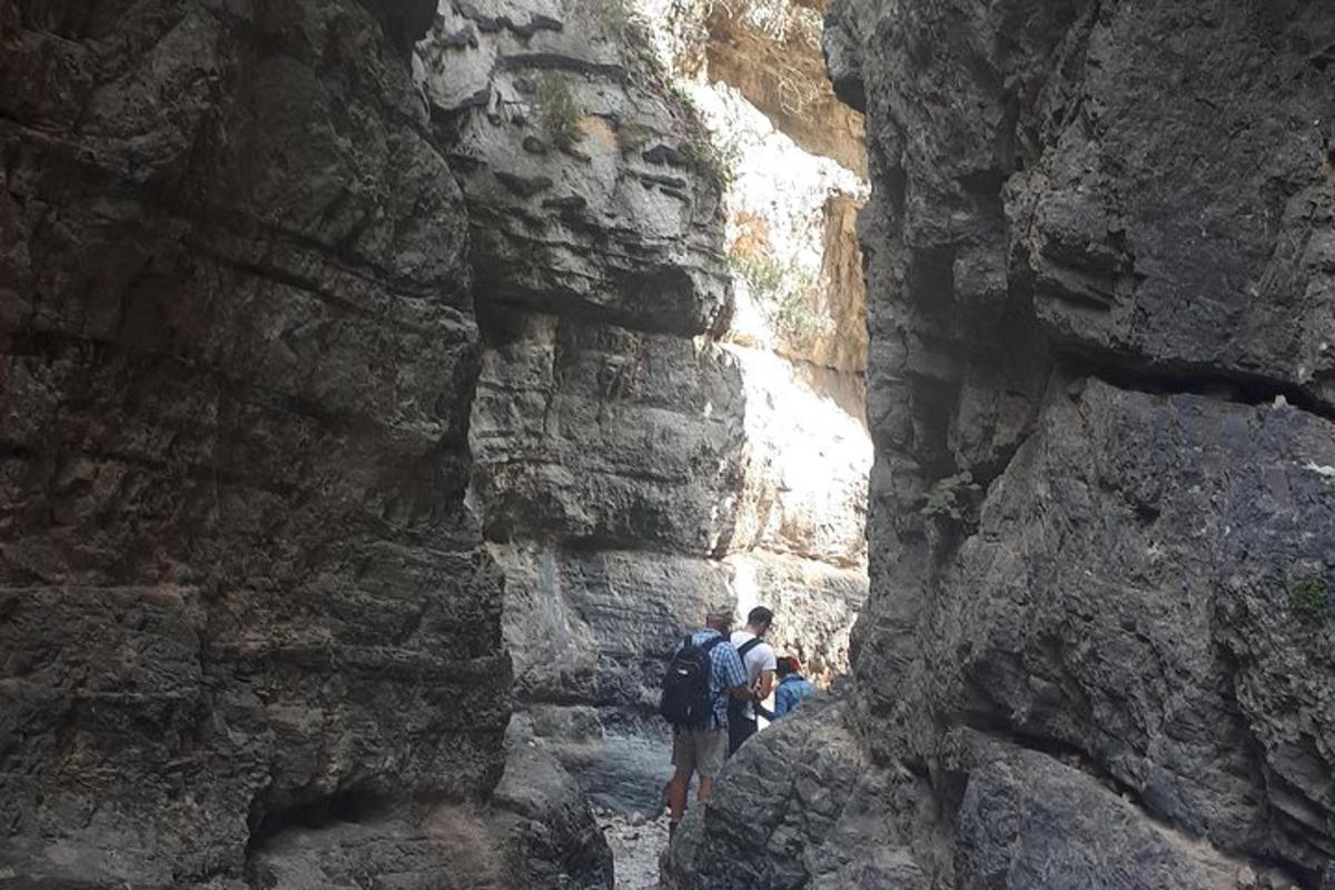 sekumpulan orang berjalan melalui dinding batu