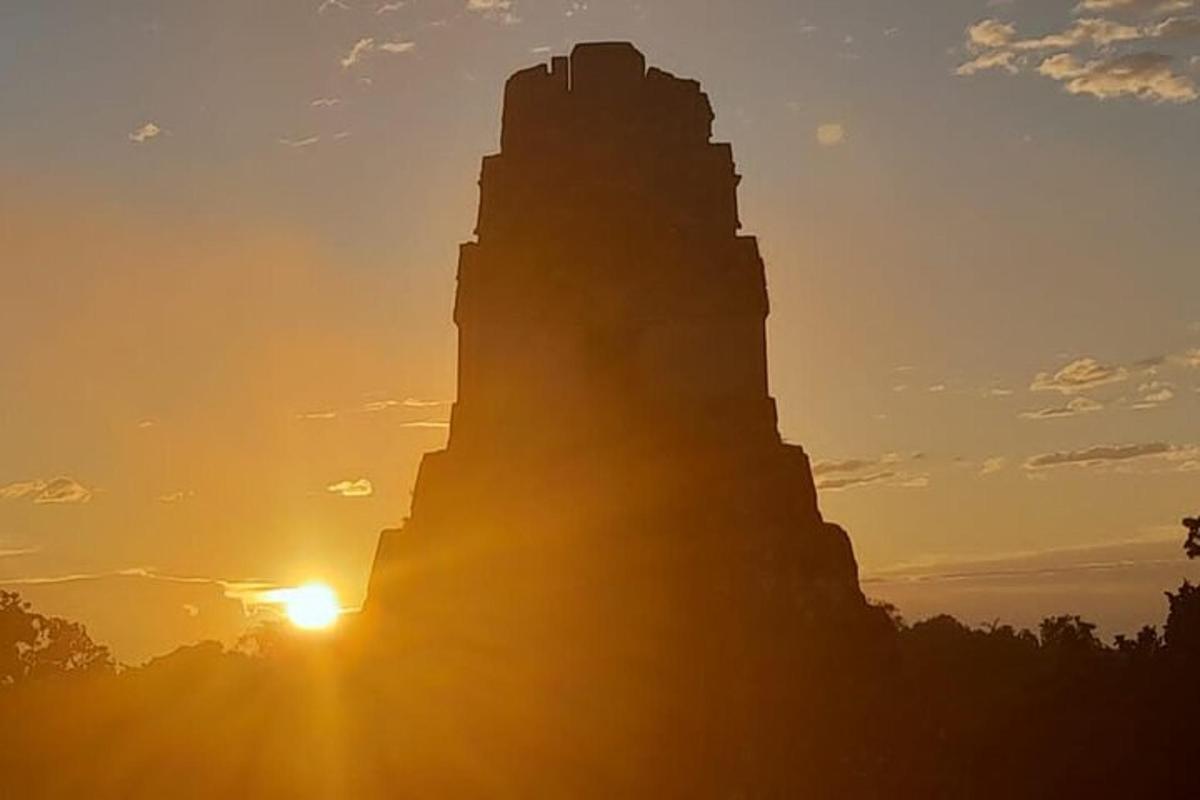 an image of the sun setting on the monument to the discoveries