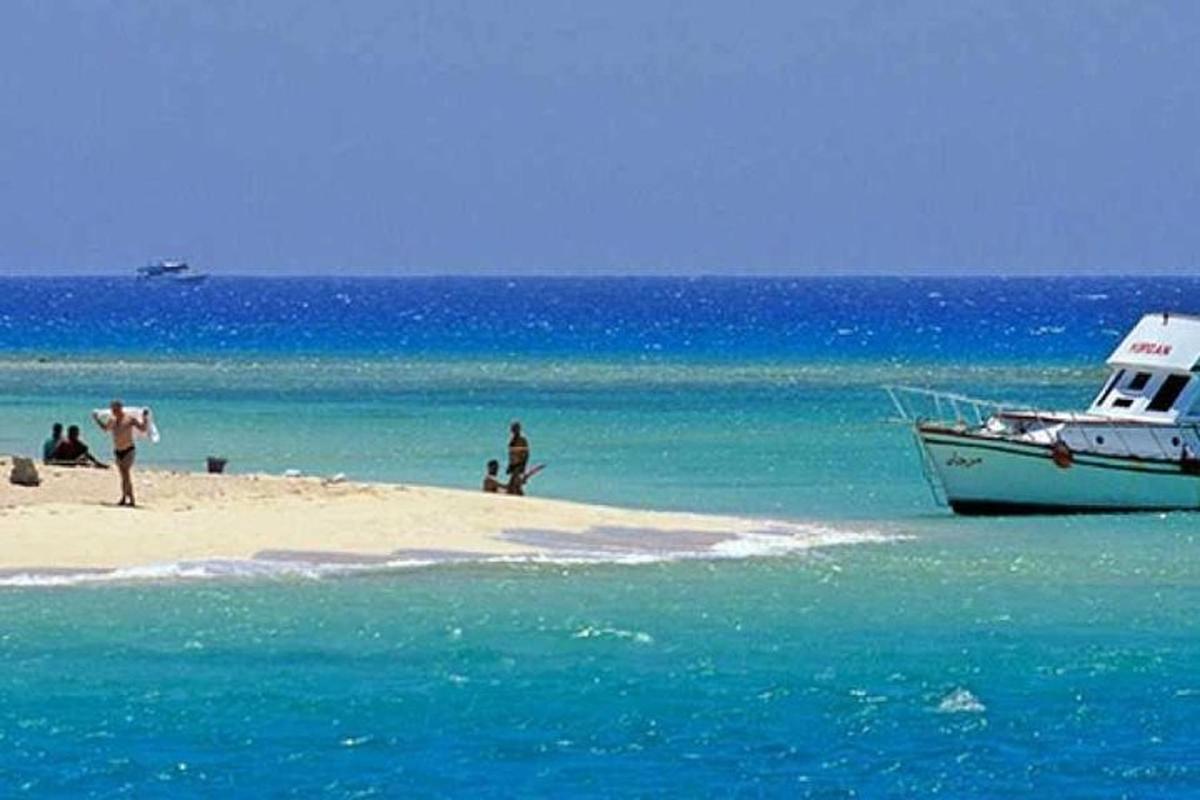 čoln, ki stoji na plaži, z ljudmi na njem