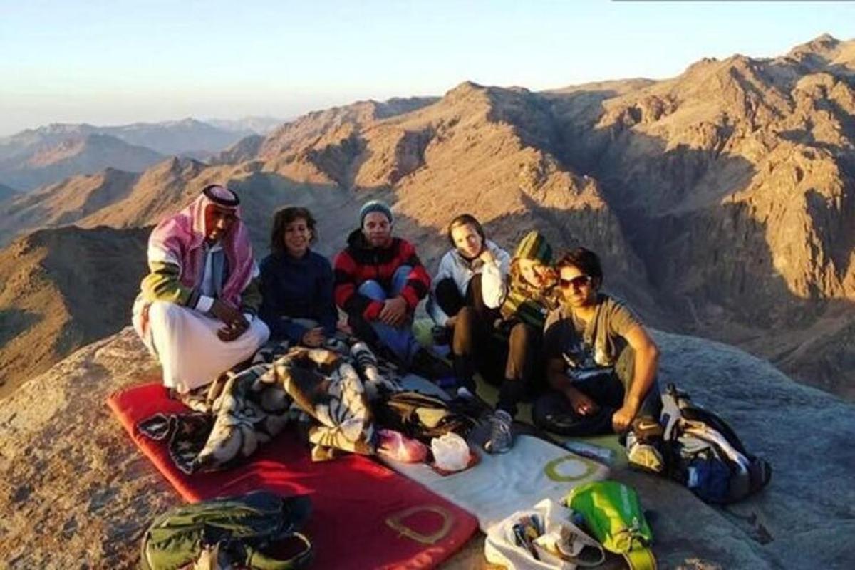 un grupo de personas sentadas en la cima de una montaña