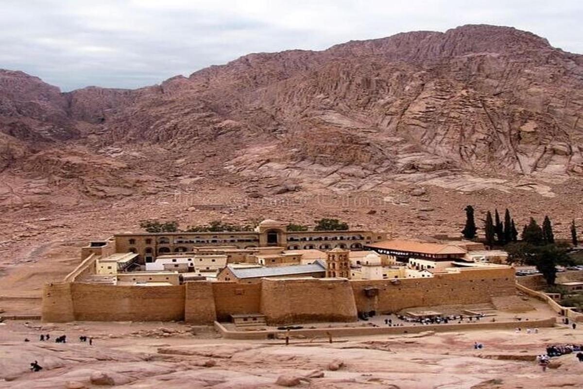 Un edificio en el desierto con una montaña al fondo.
