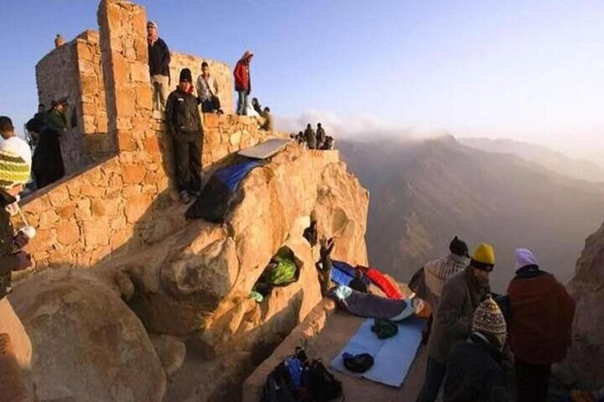 a group of people sitting on the edge of a mountain