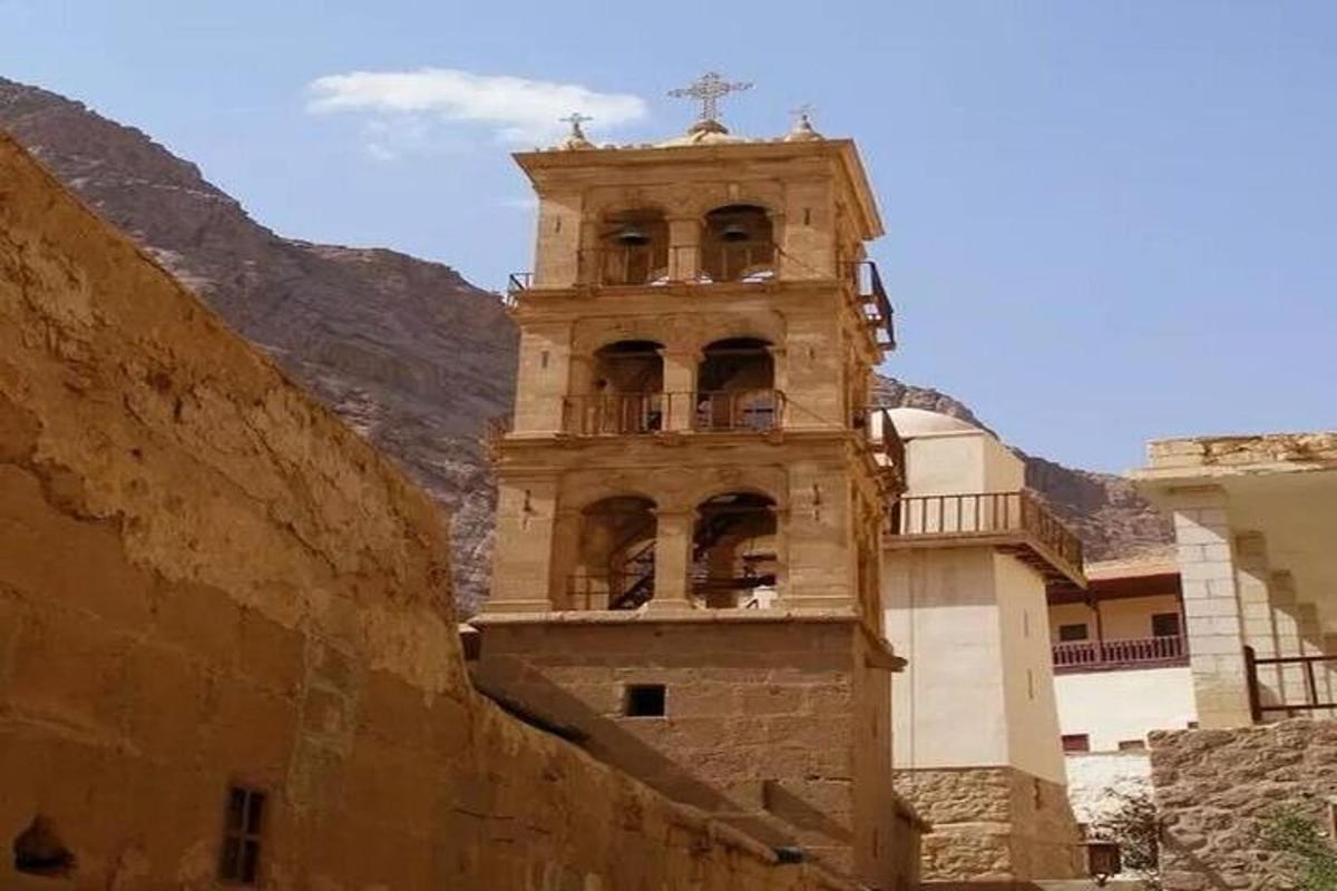 a building with a clock tower next to a mountain