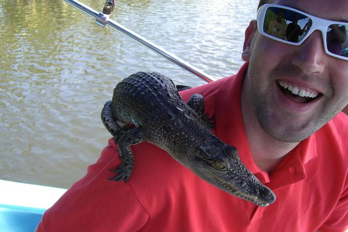 a man holding a crocodile on his shoulder
