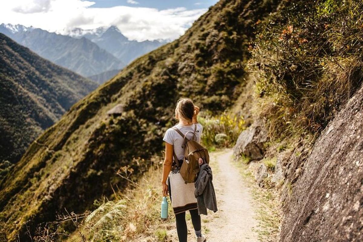 una mujer caminando por un sendero de tierra en una montaña