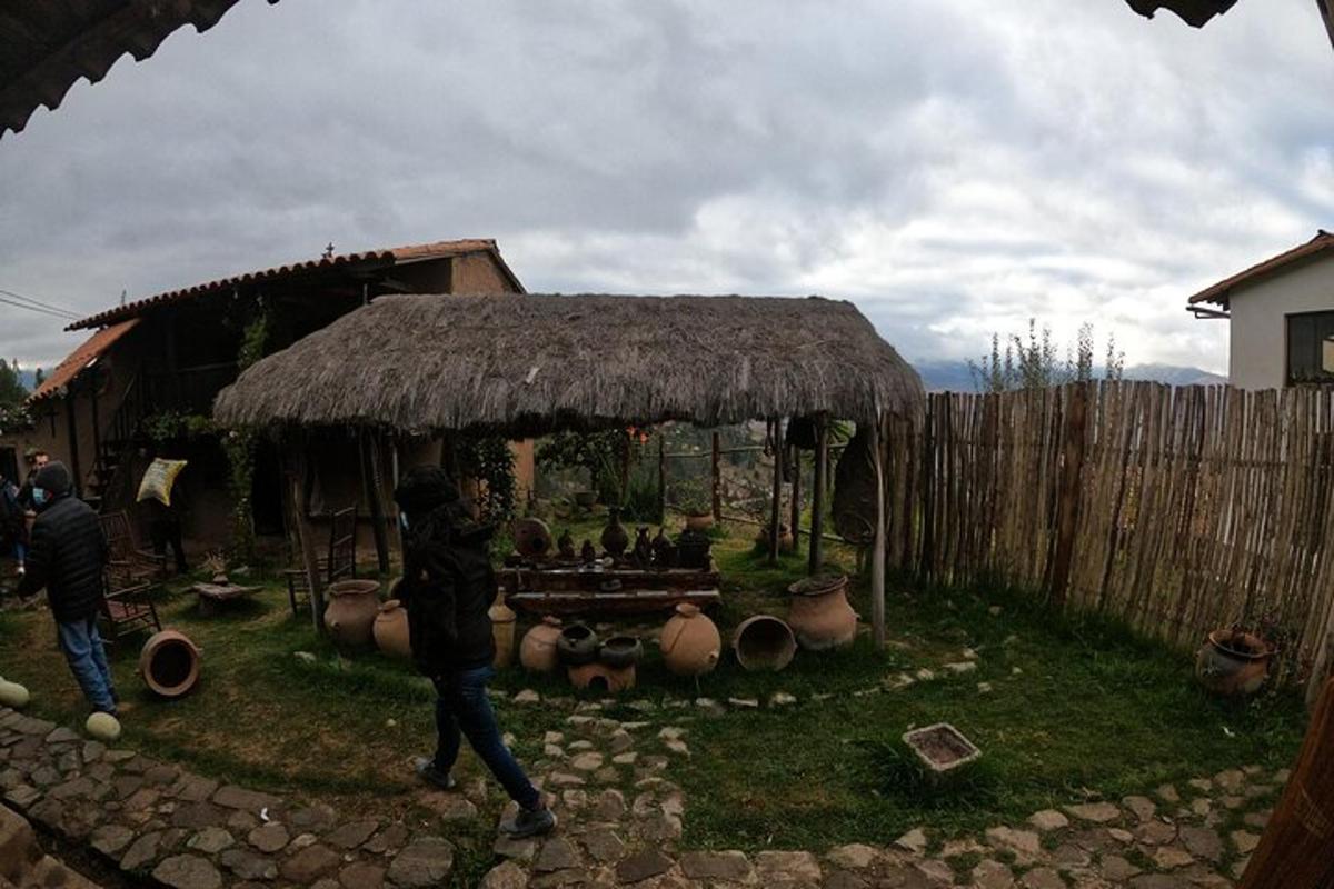 a person walking in front of a thatch hut