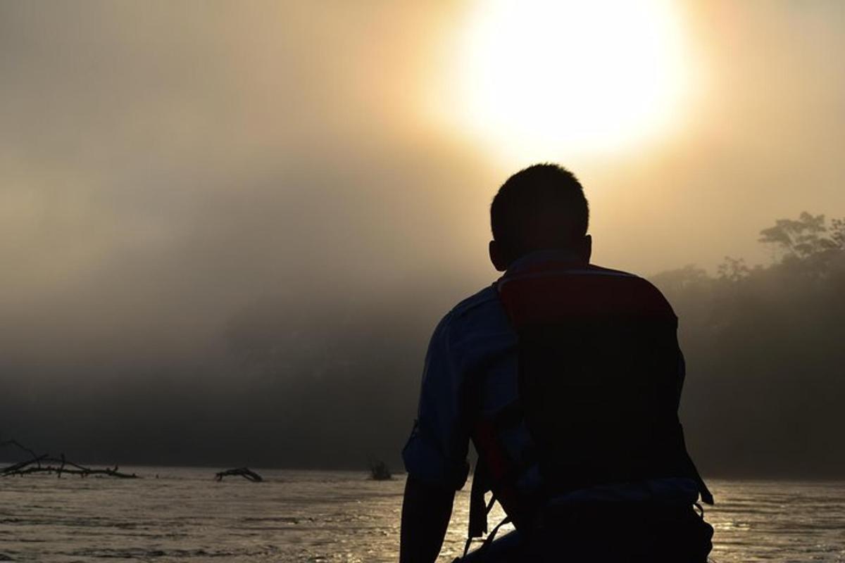 a man standing on the beach watching the sunset