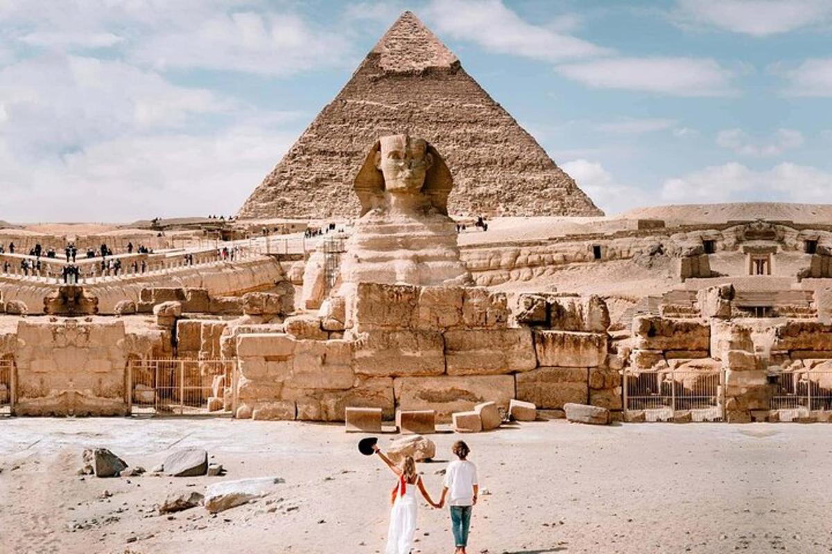 dva lidé stojící před pyramidou