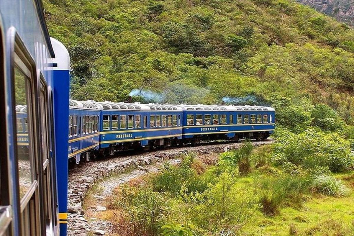 kereta api biru bergerak menuruni landasan di sebelah gunung