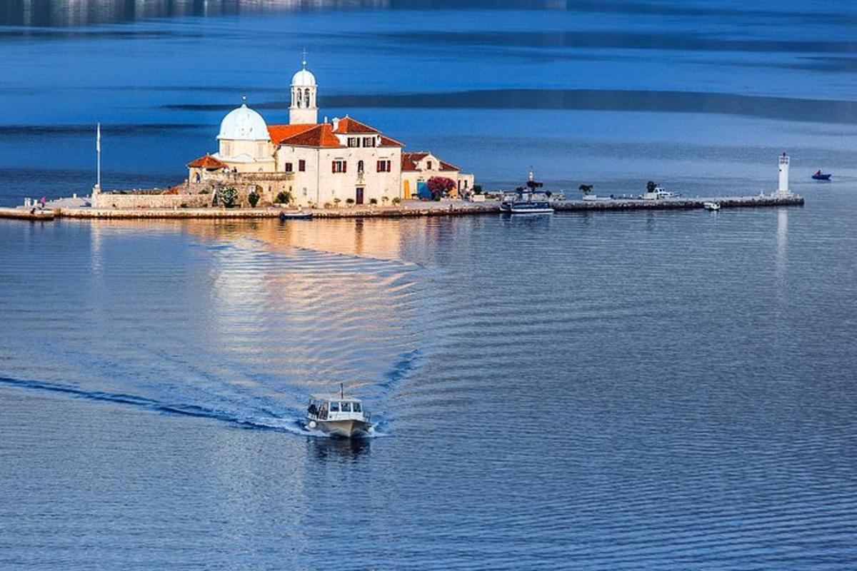 a small boat in the water in front of an island
