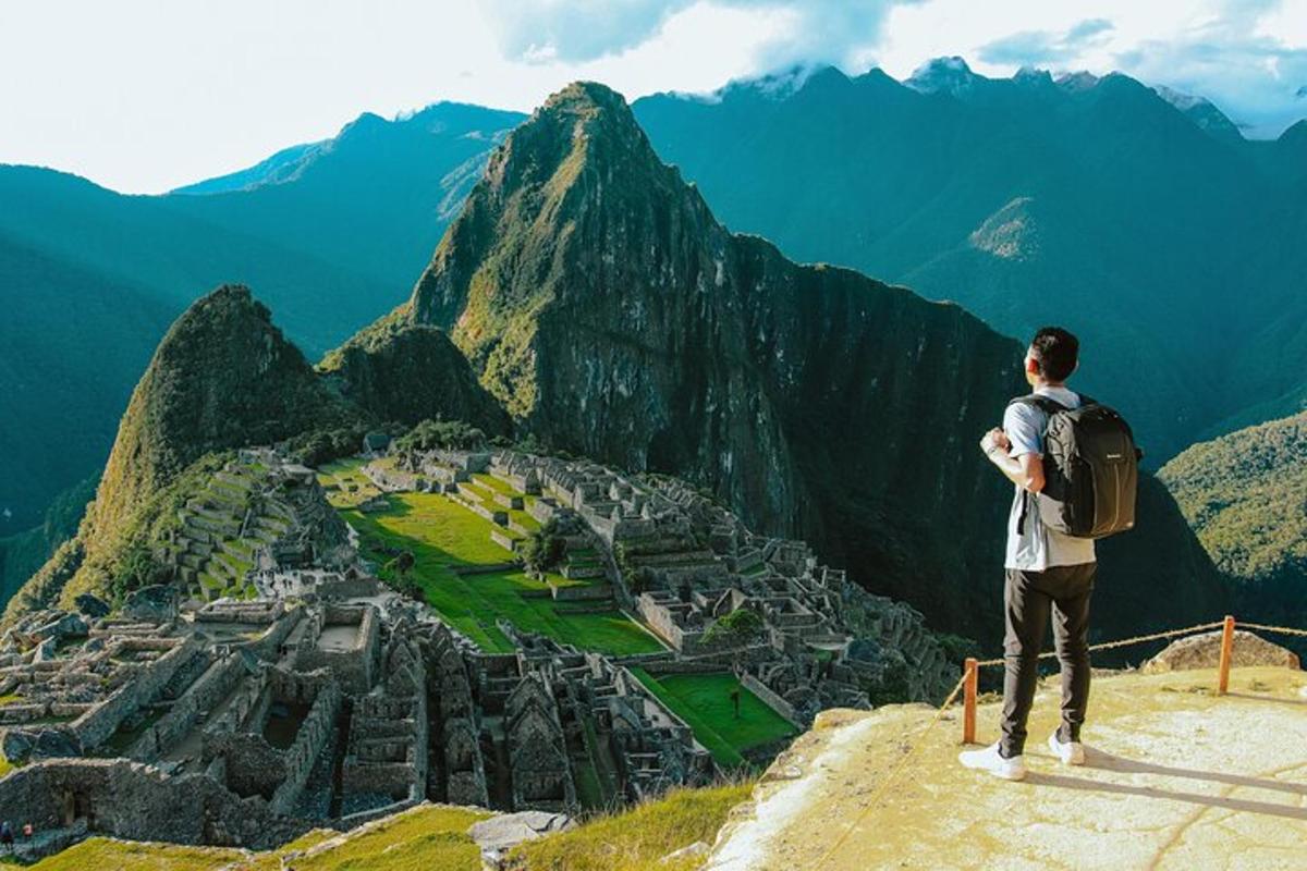 um homem em pé no topo de uma montanha olhando para uma cidade