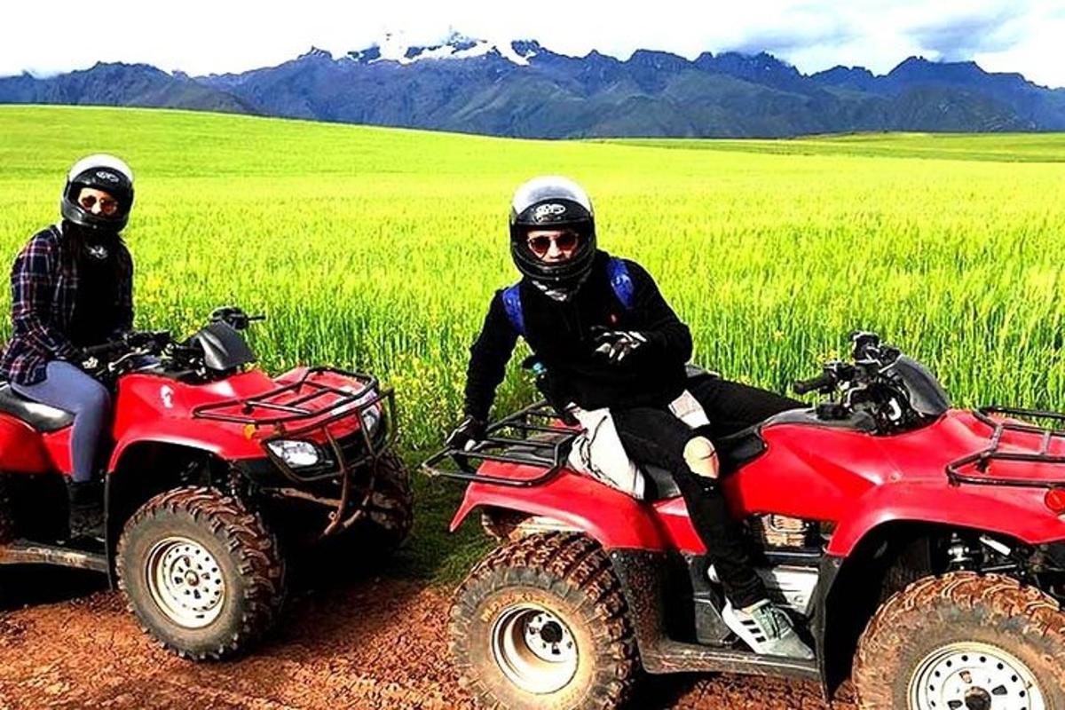 two men are sitting on atvs in a field