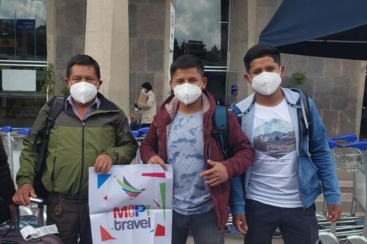 a group of three men wearing masks holding a sign