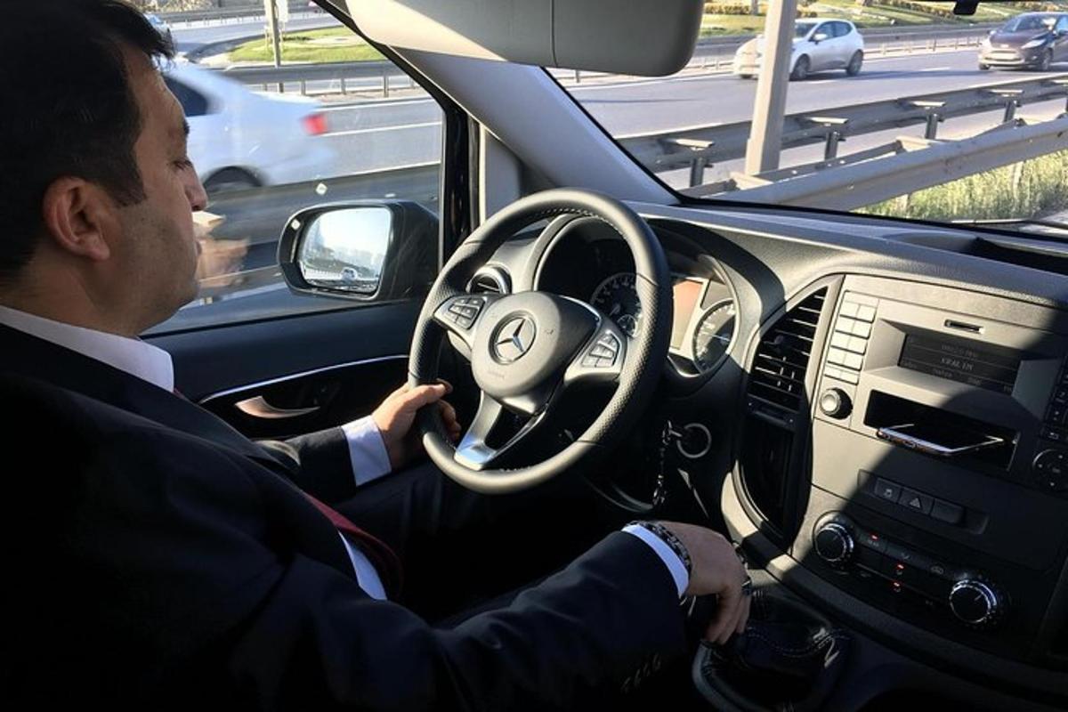 ένας άντρας με κοστούμι οδηγεί ένα αυτοκίνητο