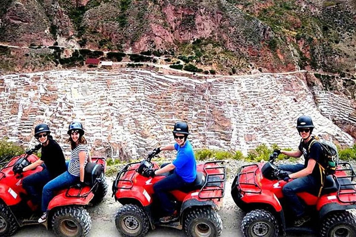 Un grupo de personas viajando en vehículos todo terreno frente a una montaña.