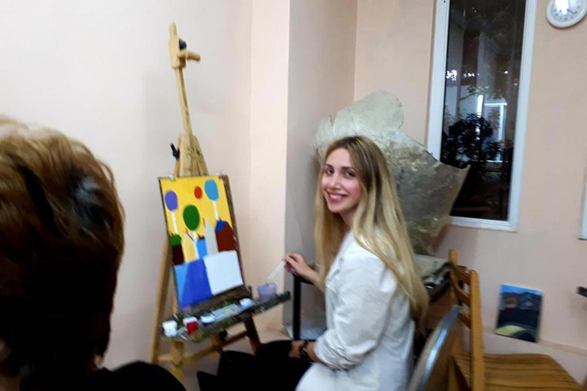 a woman is standing in front of a painting