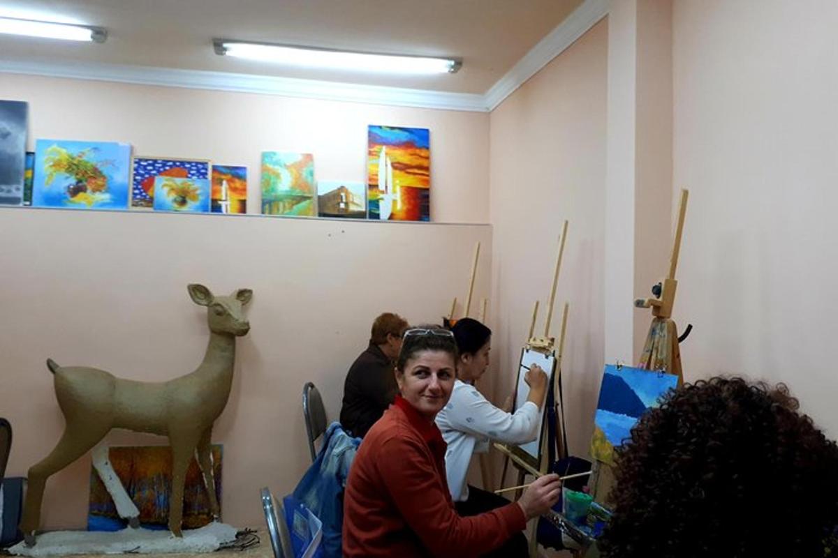 a group of people standing in a room with paintings