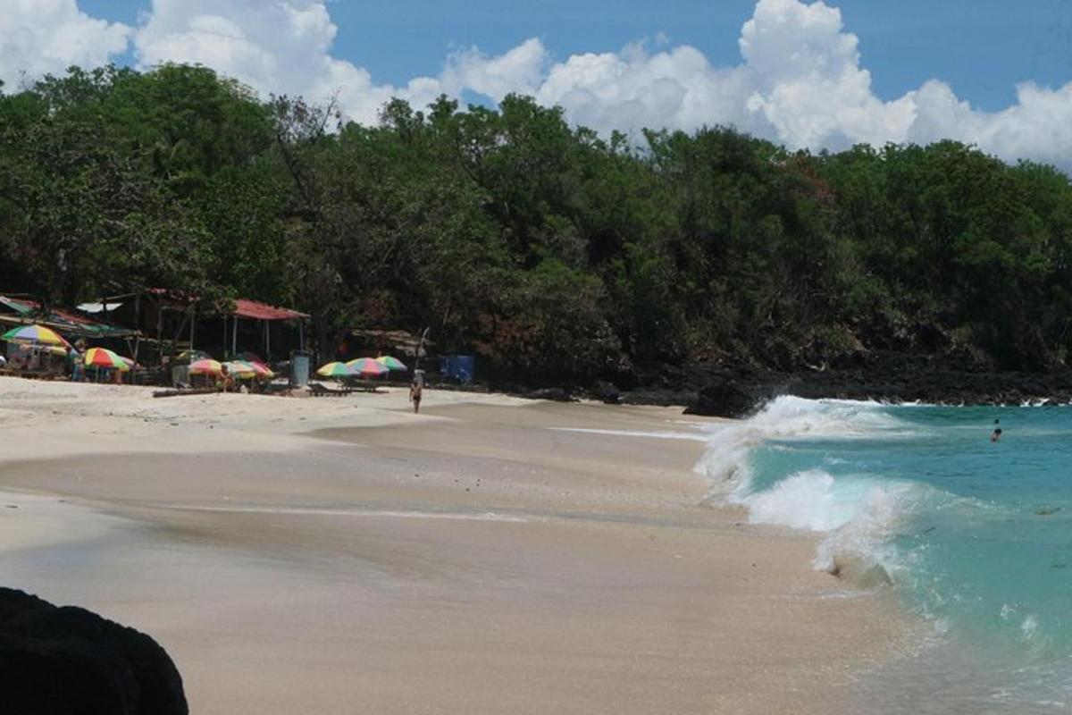 a beach with umbrellas and people on the beach